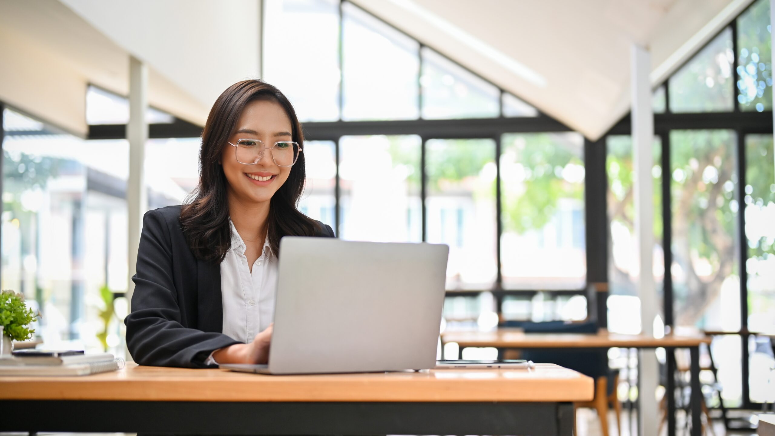 A young business professional looking very optimistic as she works.